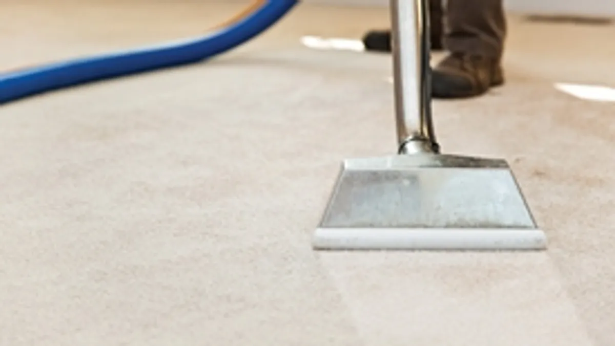 Carpet cleaning wand head gliding over a light carpet during hot-water extraction, Sarasota, FL.