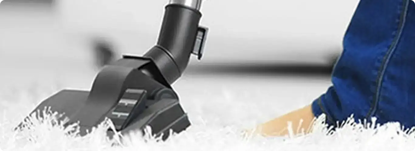 Close-up of a professional vacuuming a white carpet in Nokomis.
